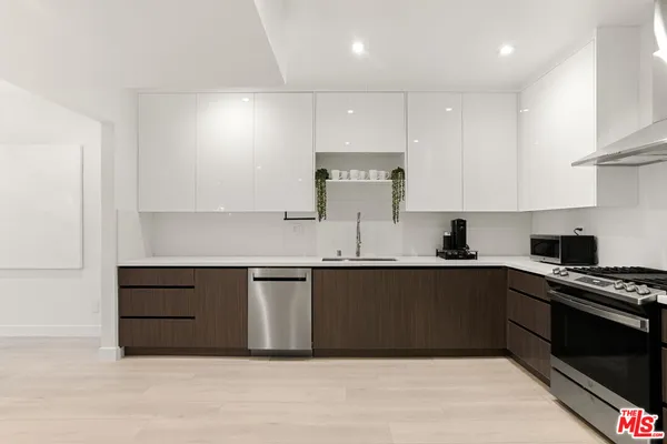 a large kitchen with kitchen island a sink a table and chairs in it