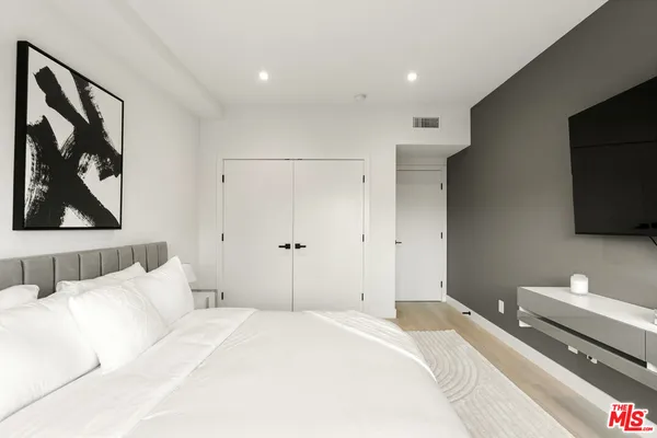 a bedroom with a bed and a large window