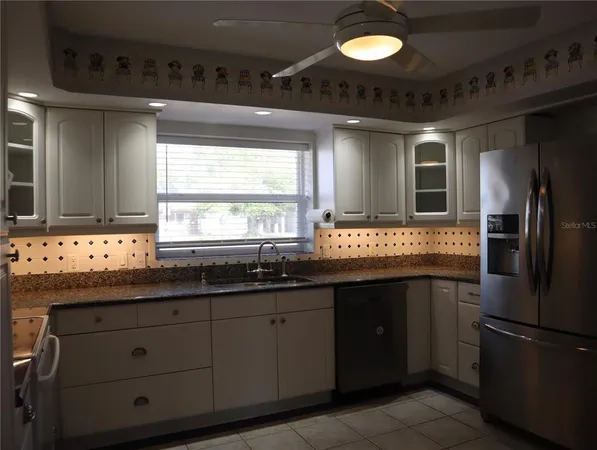a kitchen with stainless steel appliances granite countertop a sink a stove and a refrigerator