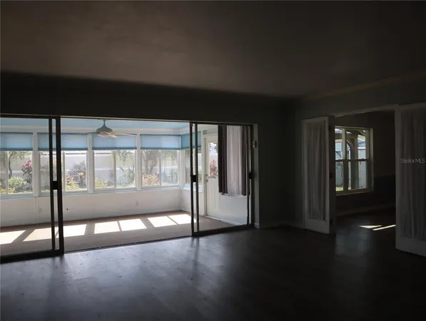 a view of an empty room with wooden floor and closet