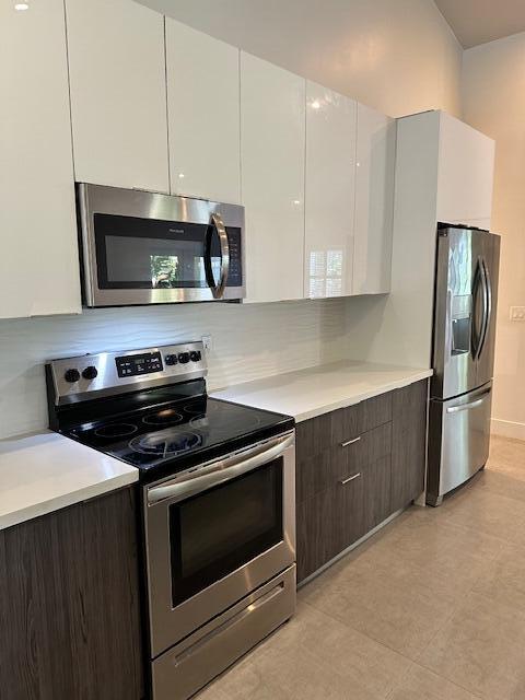 8 Bowen Drive Key Largo, FL 33037 - Photo 6 of 22 a kitchen with stainless steel appliances a stove a microwave and white cabinets