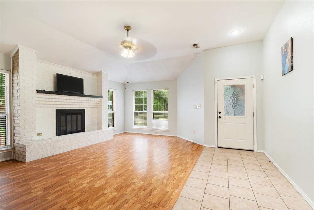 455 Timber Lakes Drive Powderly, TX 75473 - Photo 2 of 18 a view of an empty room with a fireplace and a window