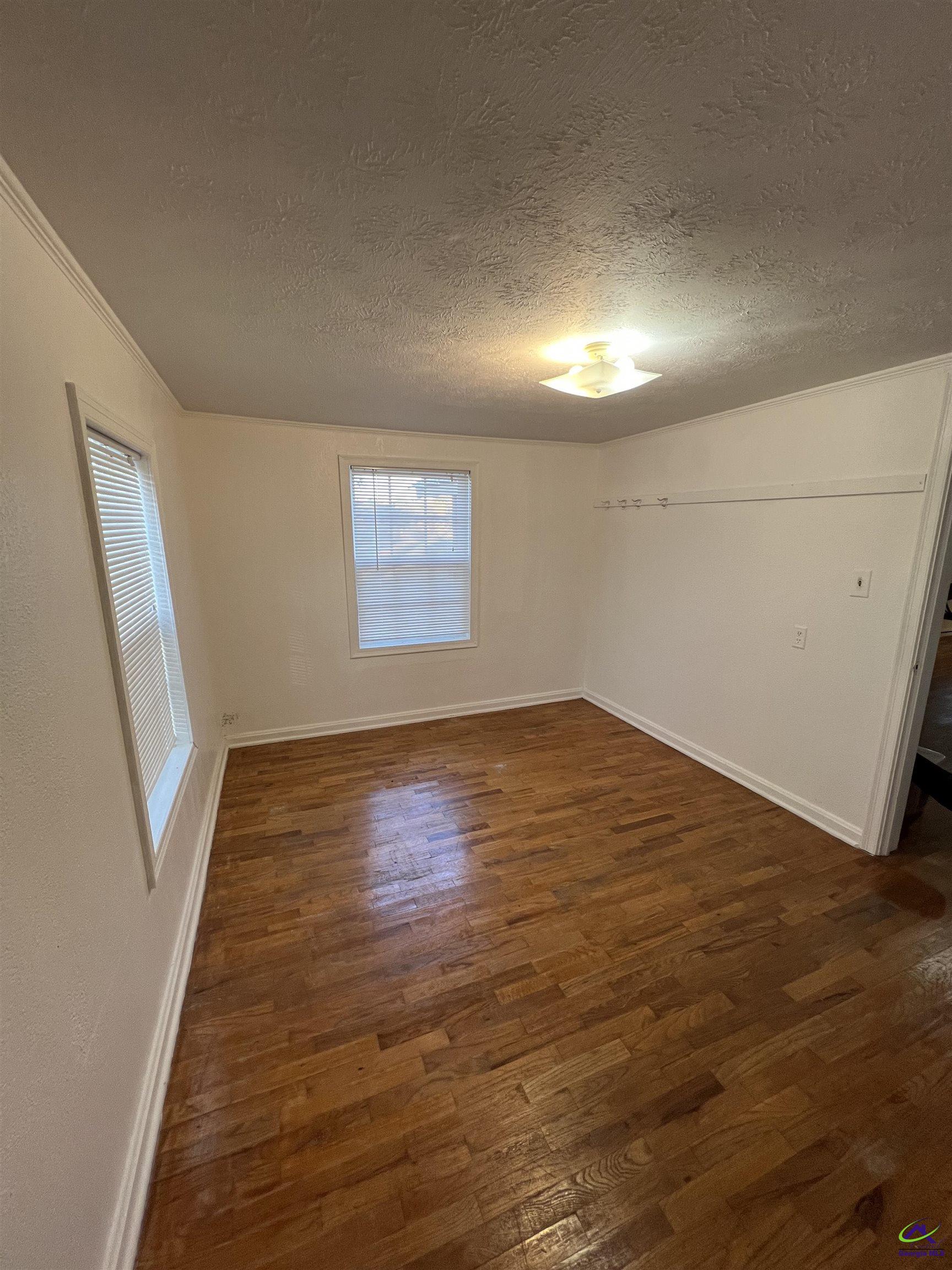 3281 State Rte 126 Dublin, GA 31021 - Photo 9 of 22 an empty room with wooden floor and windows