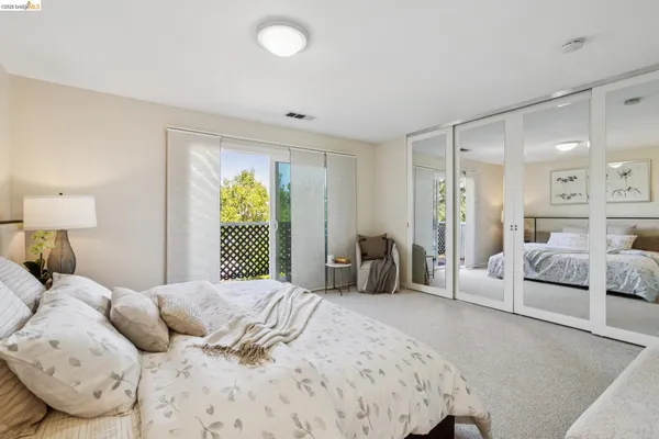 a spacious bedroom with a bed a couch and a chandelier