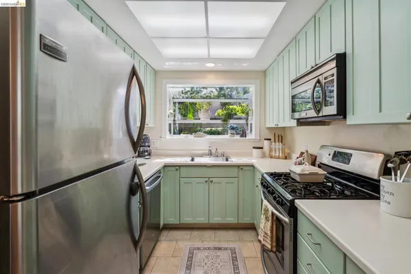 a kitchen with a sink a stove cabinets and a window