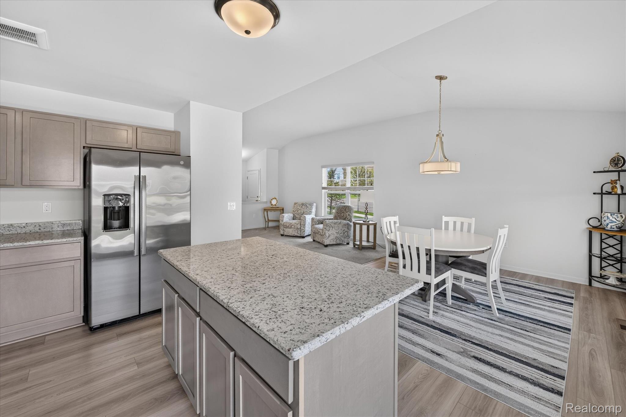 9911 Ridge Run Street Howell, MI 48855 - Photo 8 of 35 Open kitchen featuring a granite-topped island and stainless appliances.