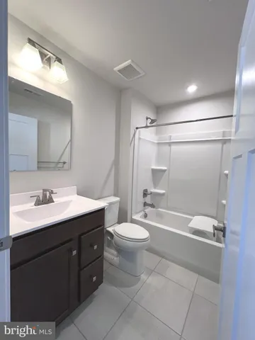 a bathroom with a double vanity sink toilet mirror and shower