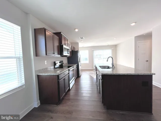 a view of a living room a kitchen with wooden floor and kitchen view