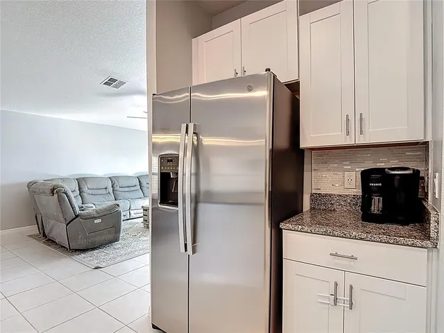 a kitchen with granite countertop a refrigerator and a cabinets