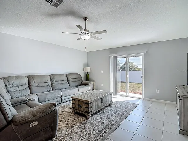 a living room with furniture and a ceiling fan