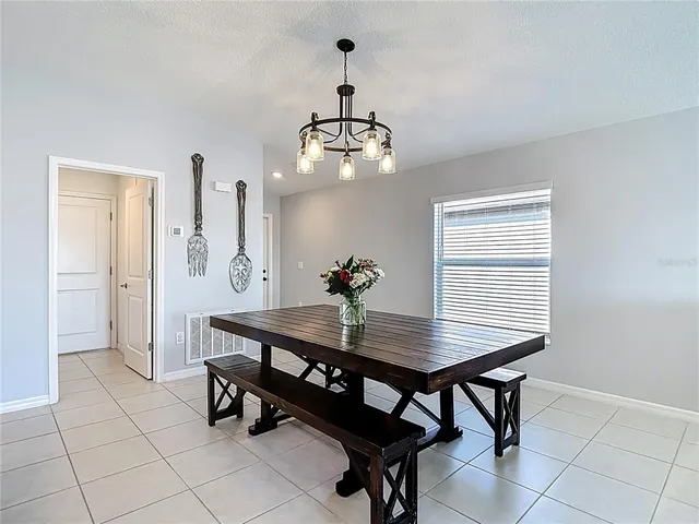 a dining room table chairs and view of kitchen