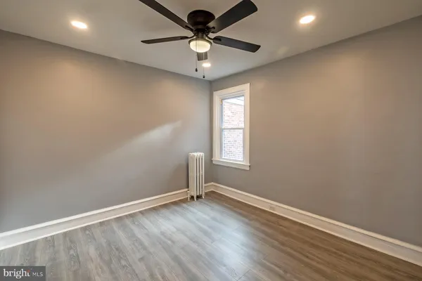 an empty room with a window and a fan