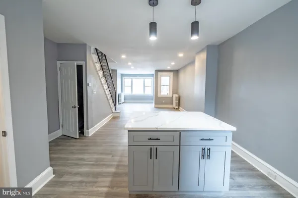 a view of a hallway with wooden floor and chandelier