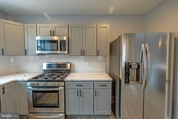 a kitchen with stainless steel appliances granite countertop a stove a refrigerator and a microwave