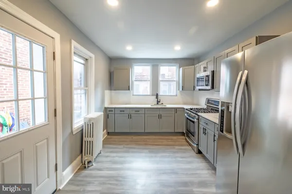 a large kitchen with a large window and stainless steel appliances