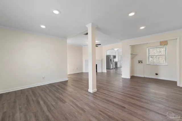 a view of empty room with wooden floor