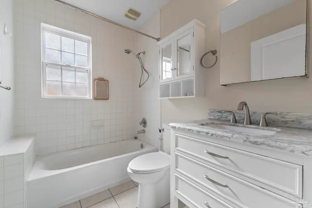 a bathroom with a granite countertop toilet a sink and bathtub