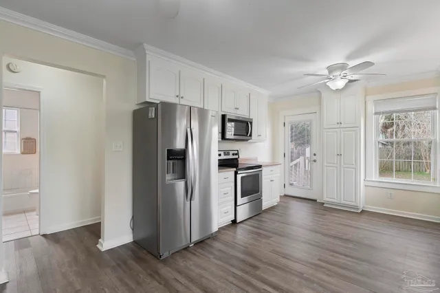 a kitchen with granite countertop a refrigerator a sink and wooden floor