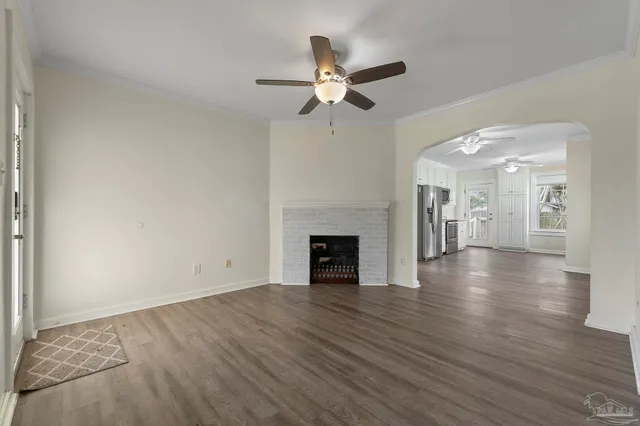 a view of a livingroom with wooden floor a ceiling fan and a window