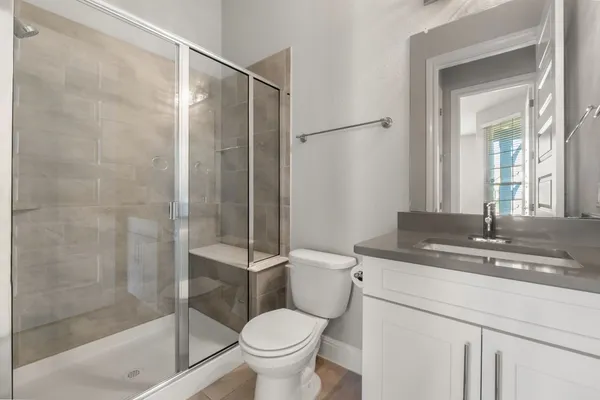 a bathroom with a granite countertop sink toilet and shower