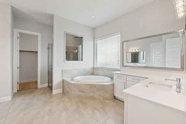 a bathroom with a granite countertop sink toilet a mirror and bathtub