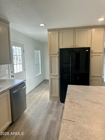 a kitchen with stainless steel appliances kitchen island granite countertop a refrigerator and a sink