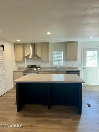 a kitchen with a sink cabinets and wooden floor