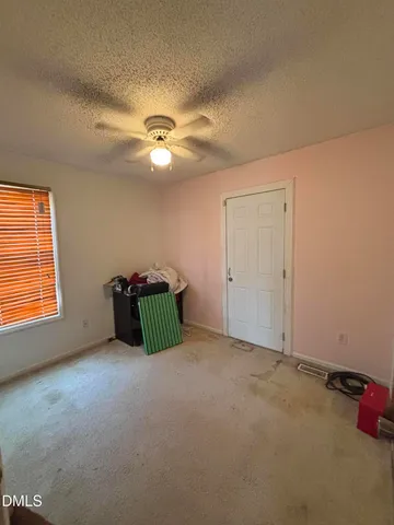 an empty room with windows and ceiling fan