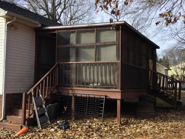 a view of wooden house with a large window and wooden fence