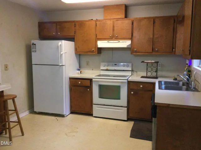a kitchen with stainless steel appliances granite countertop a refrigerator sink and stove