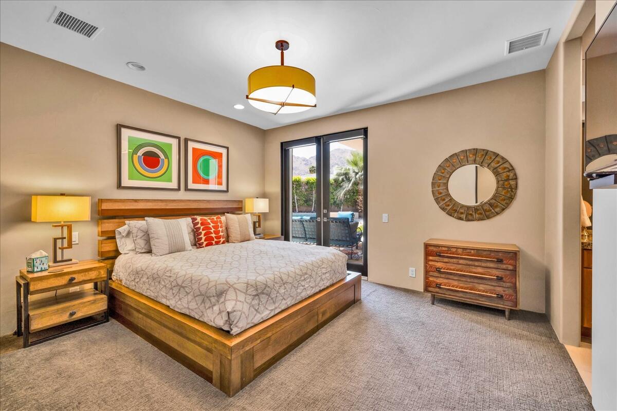 45730 Indian Canyon Road Indian Wells, CA 92210 - Photo 31 of 71 a bedroom with a bed and a painting on the wall
