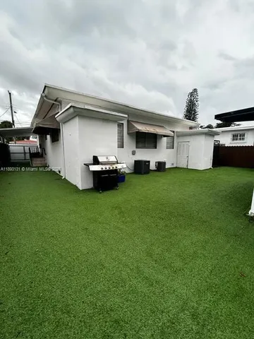 a big white house with a yard and sitting area