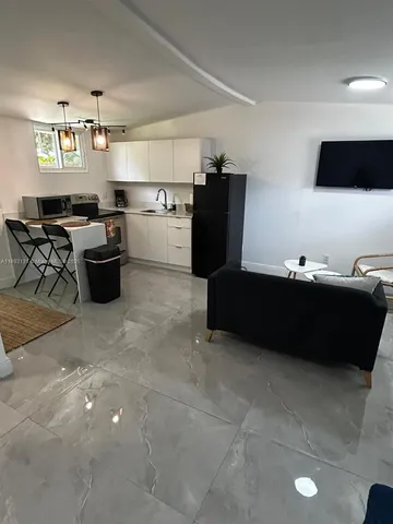 a living room with furniture and view kitchen