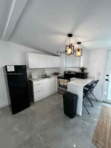 a kitchen with stainless steel appliances granite countertop a refrigerator and a stove
