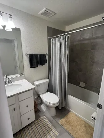 a bathroom with a sink a toilet a mirror and shower