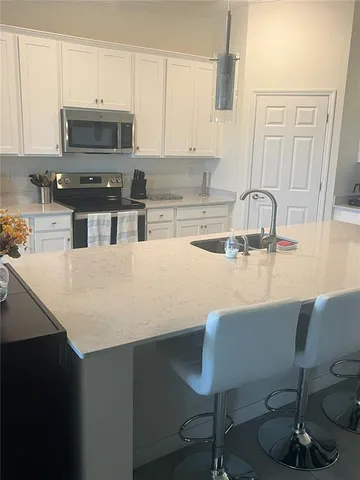 a large kitchen with kitchen island granite countertop a stove a sink dishwasher and a refrigerator