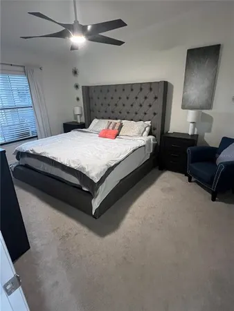 a spacious bedroom with a bed and a lamp