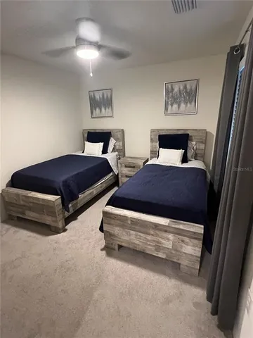 a spacious bedroom with two beds and painting on the wall