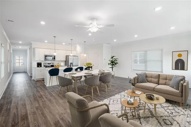 a living room with furniture a flat screen tv and a large window