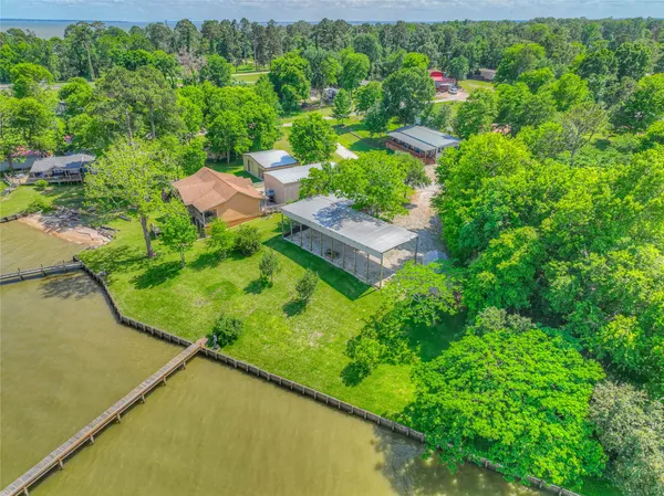 an aerial view of residential house with outdoor space and trees all around