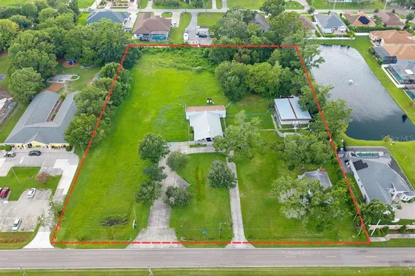 an aerial view of a house with a yard and lake view