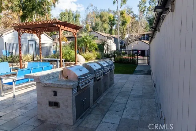 a view of a patio with couches and table and chairs under an umbrella