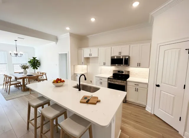 a kitchen with a sink a kitchen island and stainless steel appliances