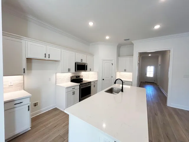 a kitchen with sink a stove and refrigerator