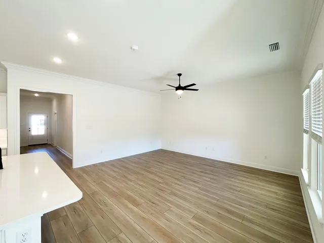a view of empty room with wooden floor