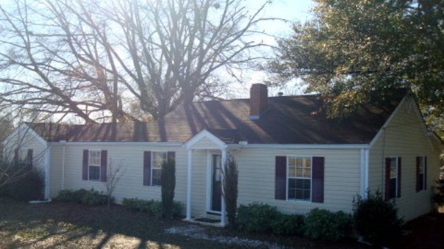 a front view of a house with yard and green space