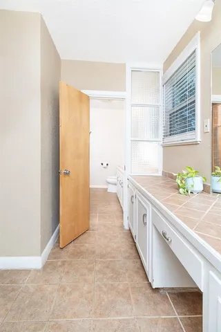 a large white kitchen with granite countertop a sink and a granite counter tops