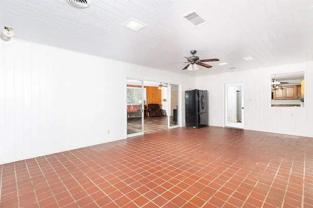 a view of a room with a ceiling fan and window