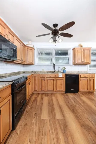 a large kitchen with stainless steel appliances granite countertop a stove sink and cabinets