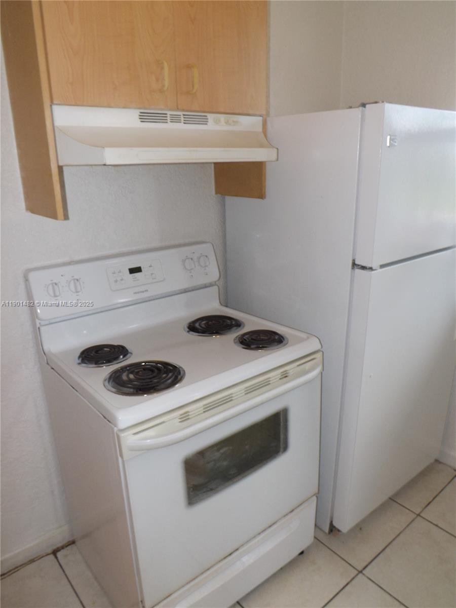 a white stove top oven sitting inside of a kitchen